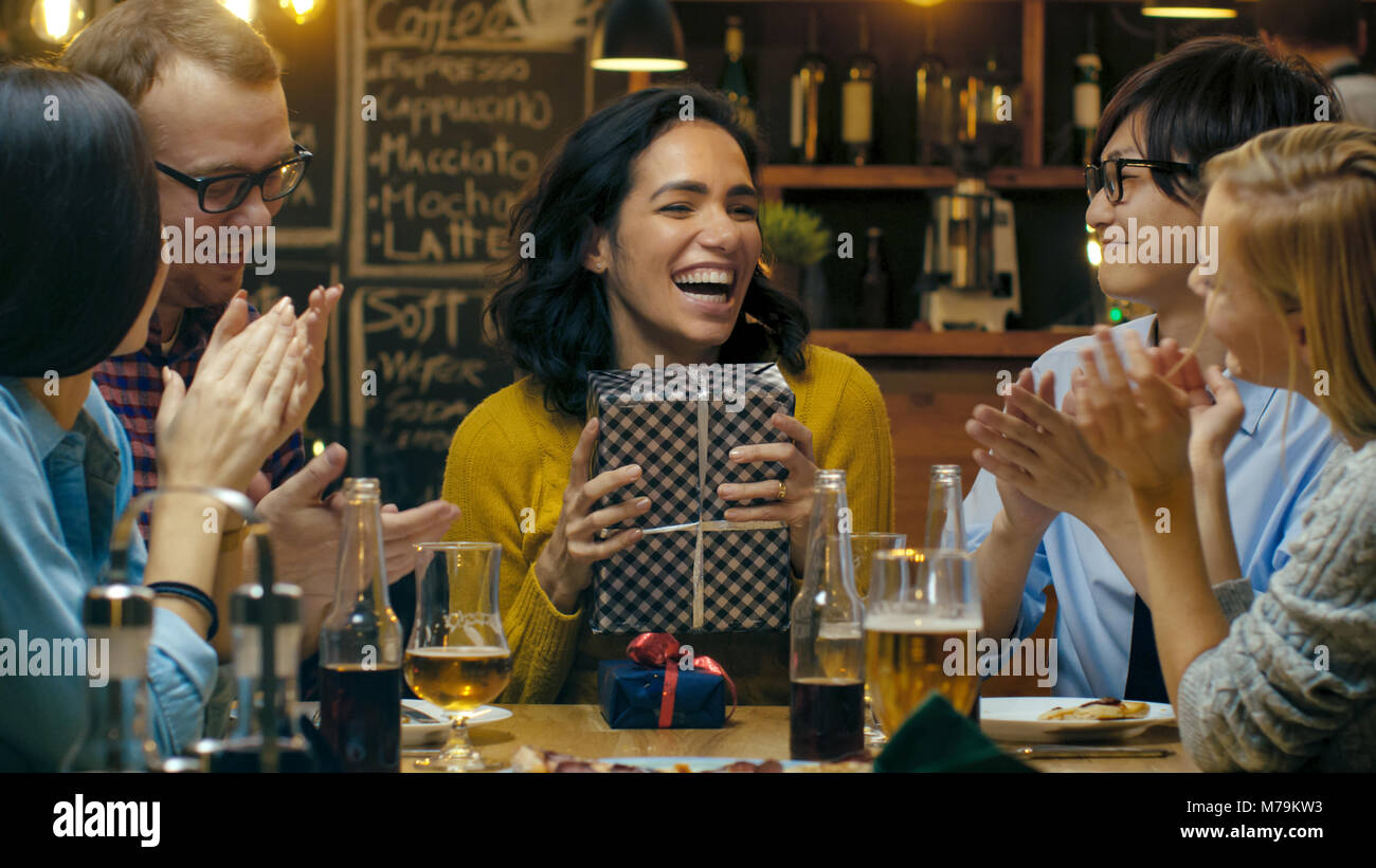 In der Bar/Restaurant Schöne Hispanic Frau bekommt Geschenke und Glückwünsche von Ihrer besten Freunde. Jeder ist glücklich! Stockfoto