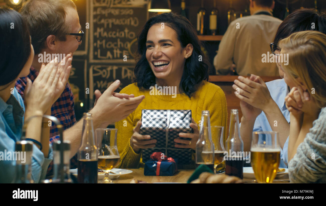 In der Bar/Restaurant Schöne Hispanic Frau bekommt Geschenke und Glückwünsche von Ihrer besten Freunde. Jeder ist glücklich! Stockfoto