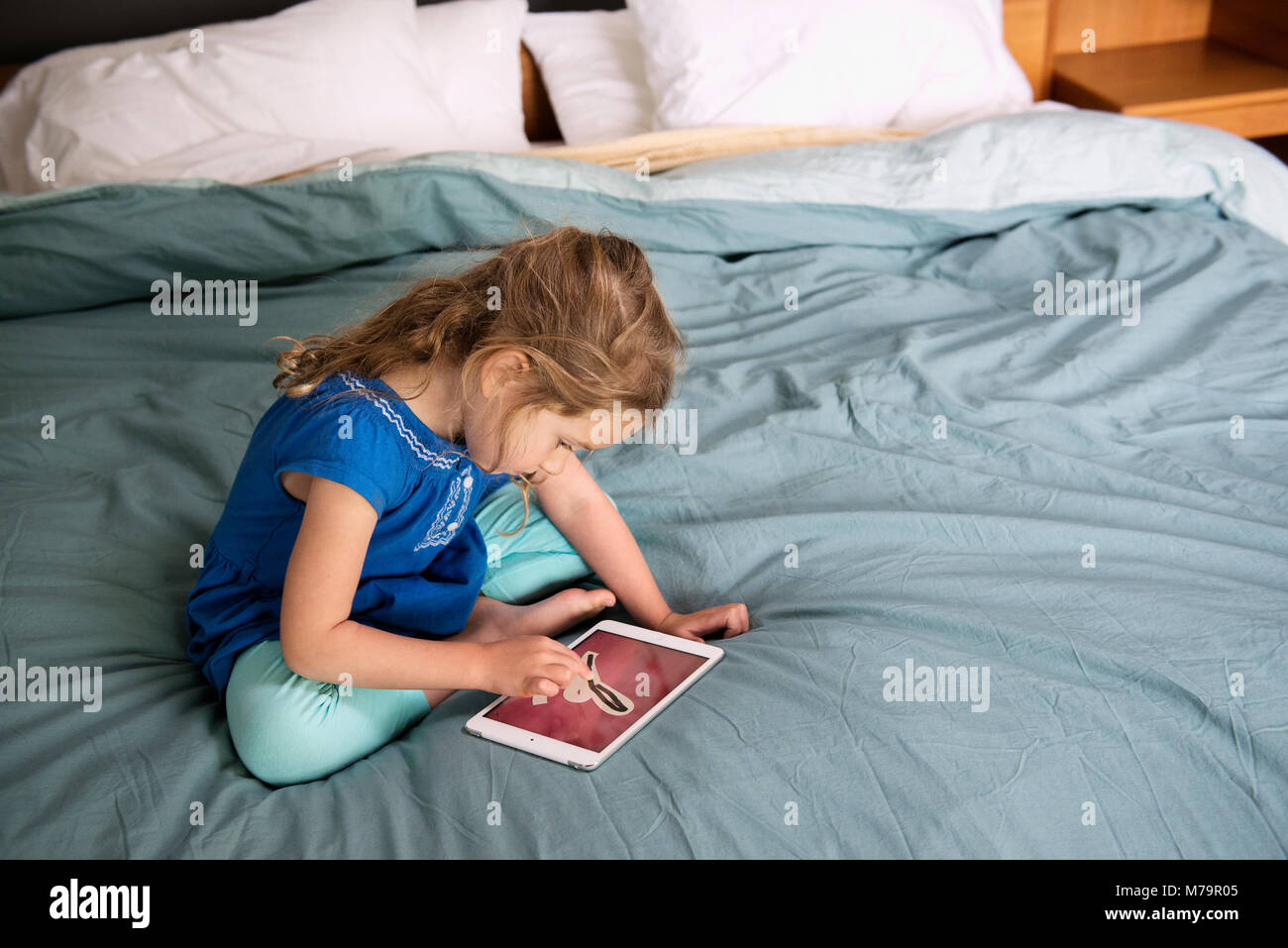 Ein Mädchen mit einem ipad mini, um zu erfahren, wie Sie schreiben. Stockfoto
