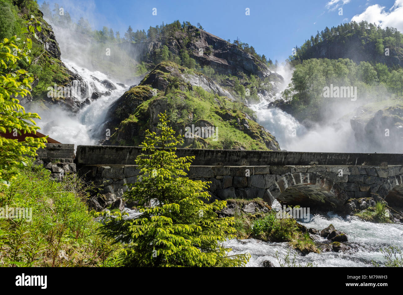 Die Twin Falls Wasserfall Latefossen mit weißen Wasser donnernd den Berg unter der steinernen Brücke auf der Straße 13 in Hordaland, Norwegen. Stockfoto