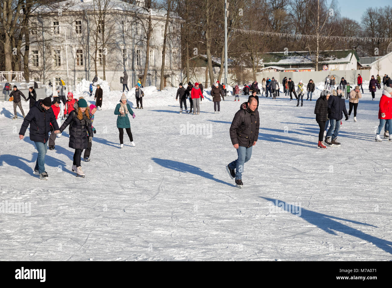 Sankt Petersburg, Russland - MÄRZ 04, 2018: Viele Leute Eislaufen auf der Eisbahn auf Elagin Insel im Winter sonnige Tage Stockfoto