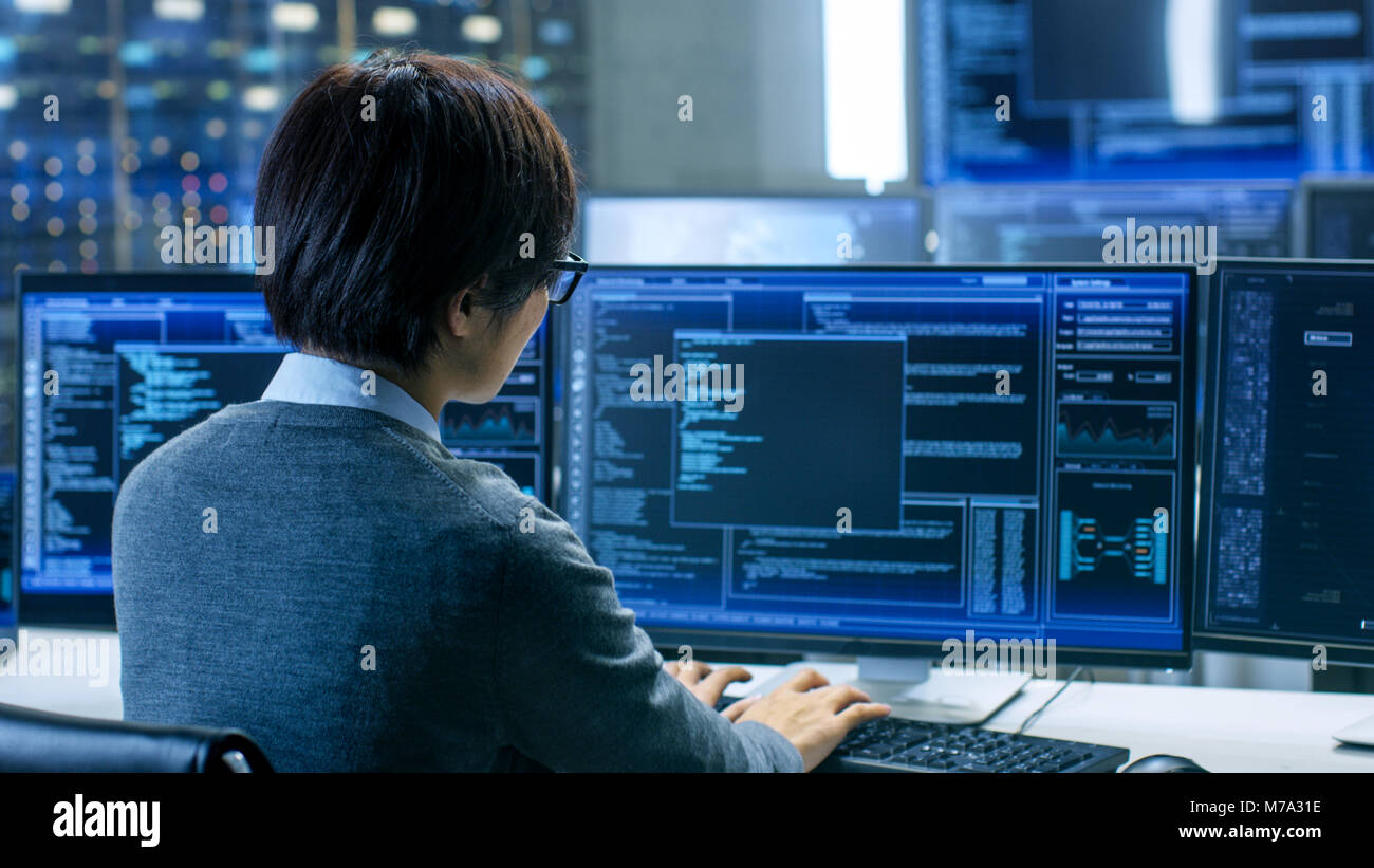 Im System Control Room Technische Operator arbeitet an seinem Arbeitsplatz mit mehreren Displays zur Anzeige von Grafiken. IT-Techniker arbeitet auf AI Forschung Stockfoto