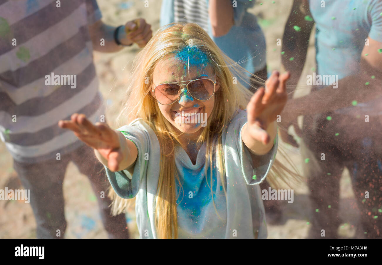 High Angle Shot der ein blondes Mädchen werfen Bunte Pulver in der Menschenmenge inmitten Hindu Holi Festival feiern. Sie haben riesigen Spaß an diesem Tag Stockfoto