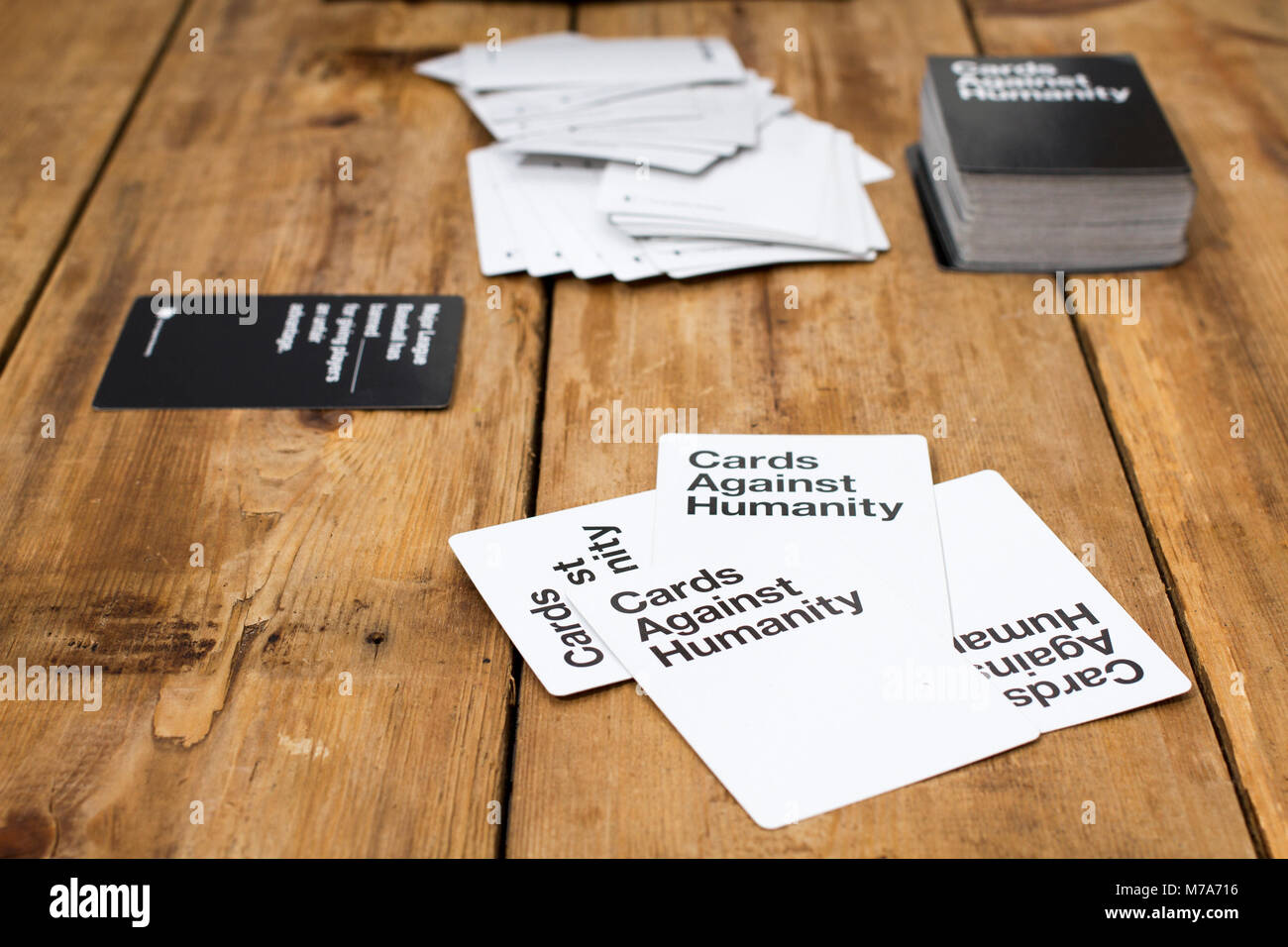 Karten gegen die Menschlichkeit, ein Party Spiel für grausamen Menschen, dargestellt auf einem Holztisch Stockfoto