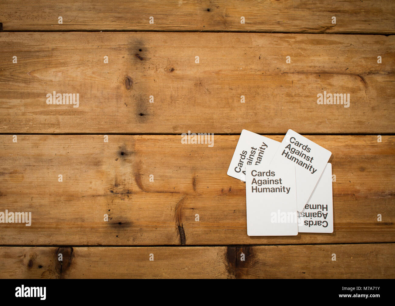 Karten gegen die Menschlichkeit, ein Party Spiel für grausamen Menschen, dargestellt auf einem Holztisch Stockfoto