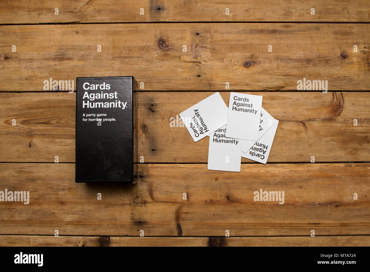 Karten gegen die Menschlichkeit, ein Party Spiel für grausamen Menschen, dargestellt auf einem Holztisch Stockfoto