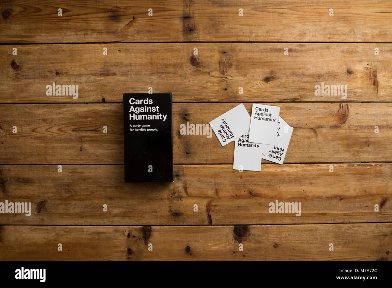 Karten gegen die Menschlichkeit, ein Party Spiel für grausamen Menschen, dargestellt auf einem Holztisch Stockfoto