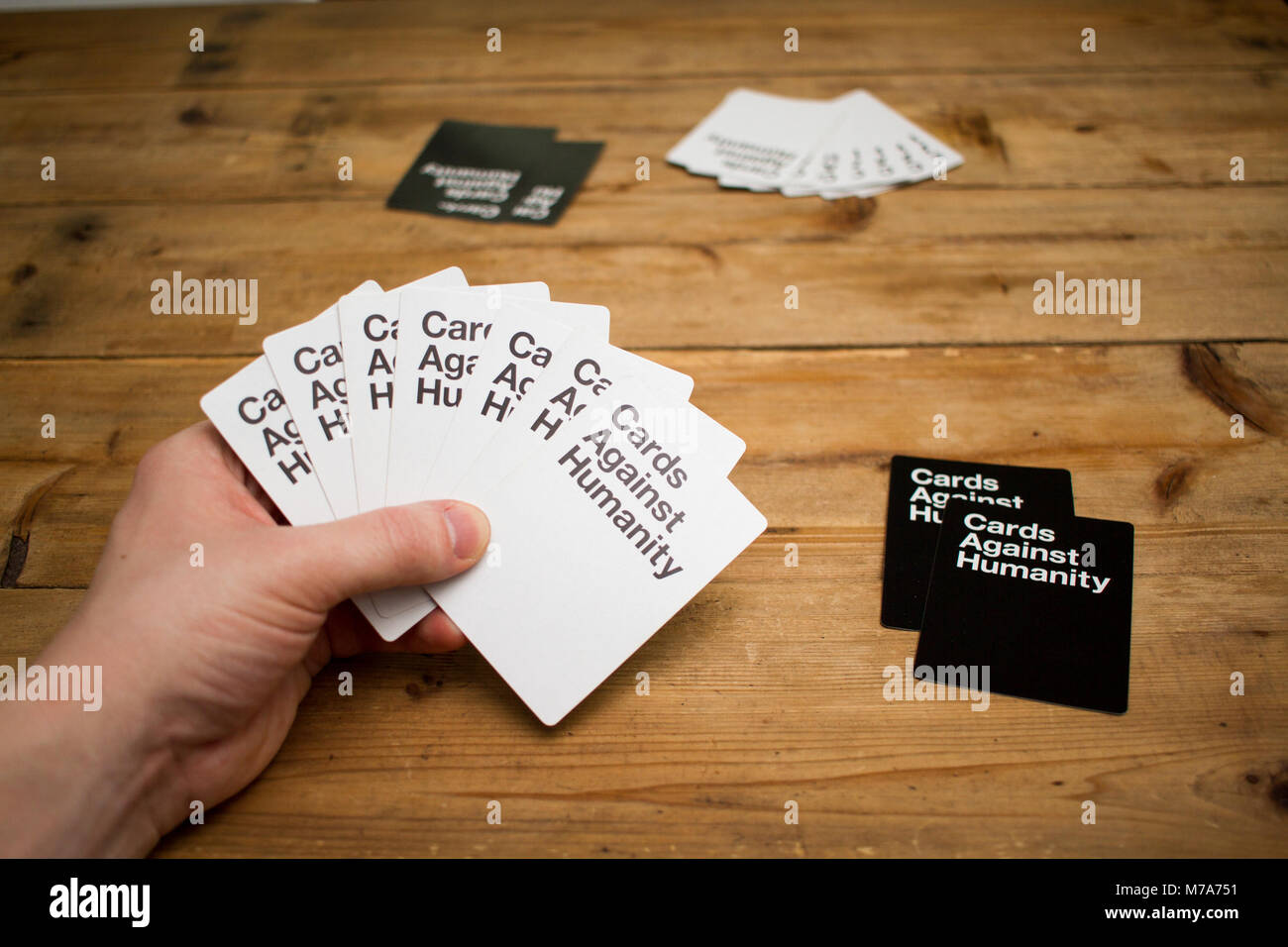 Karten gegen die Menschlichkeit, ein Party Spiel für grausamen Menschen, dargestellt auf einem Holztisch Stockfoto