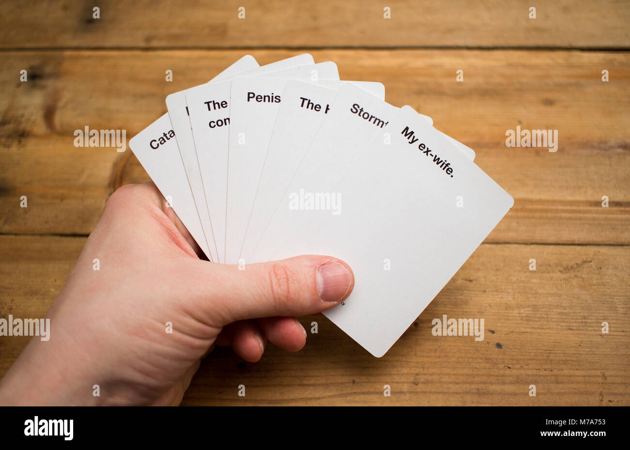 Karten gegen die Menschlichkeit, ein Party Spiel für grausamen Menschen, dargestellt auf einem Holztisch Stockfoto
