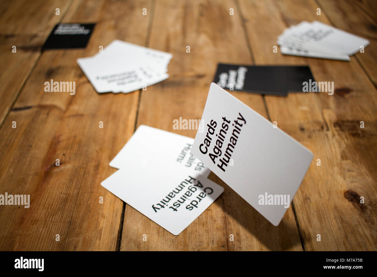 Karten gegen die Menschlichkeit, ein Party Spiel für grausamen Menschen, dargestellt auf einem Holztisch Stockfoto