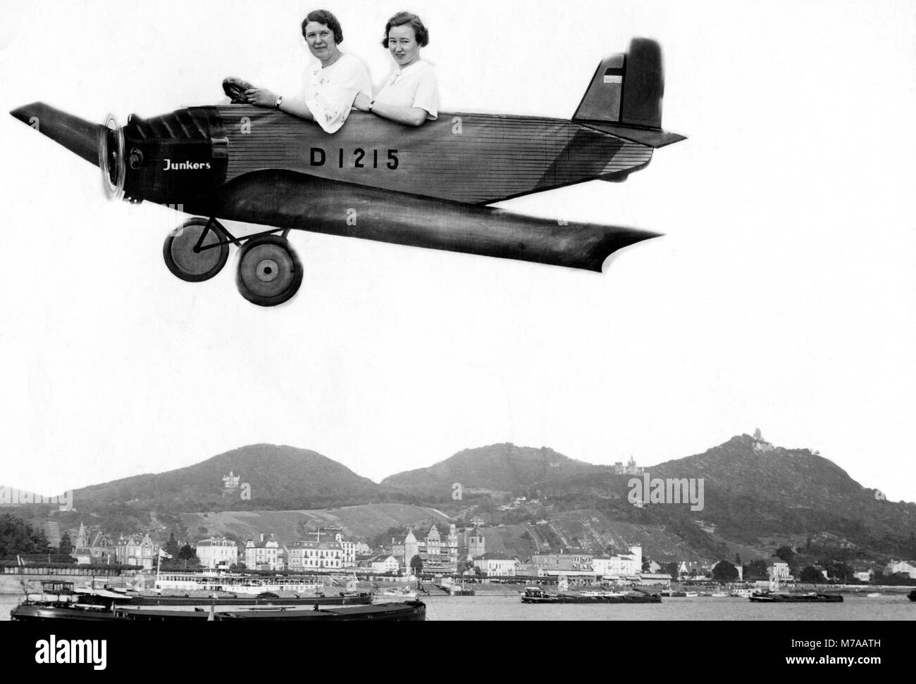 Zwei Frauen fliegen in einem Karton Flugzeug über dem Rhein, 1930er Jahre, Deutschland Stockfoto