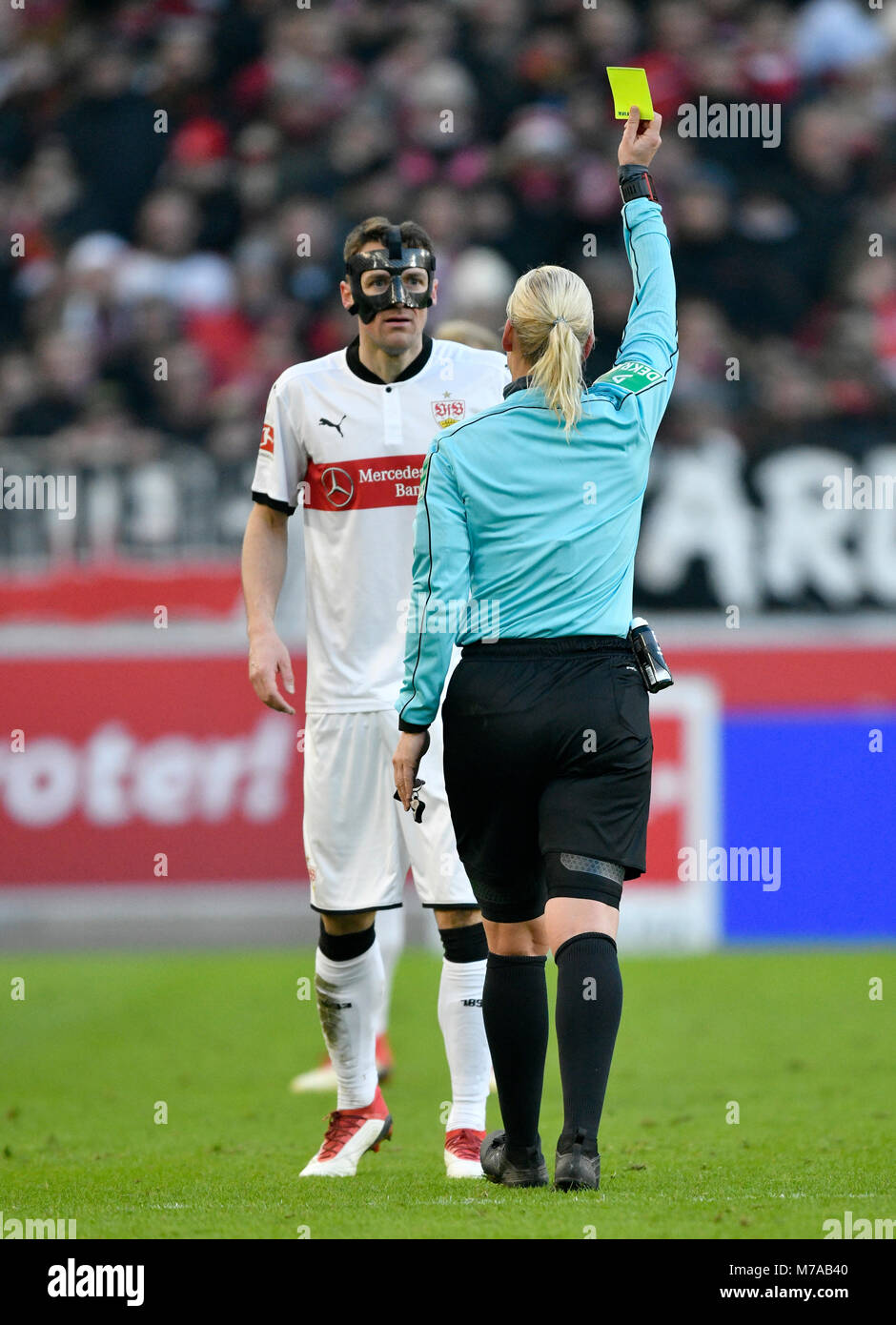 Schiedsrichter Bibiana Steinhaus zeigt Christian Gentner des VfB Stuttgart mit Gesichtsmaske die gelbe Karte, Mercedes-Benz Arena Stockfoto
