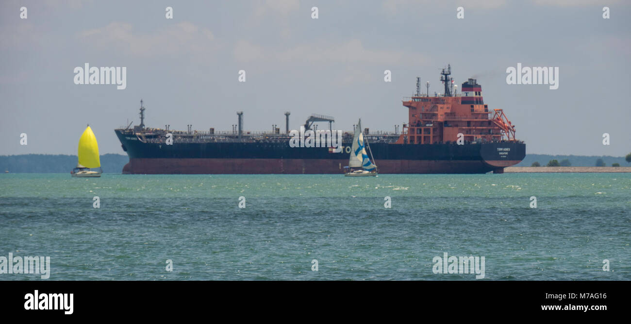 Zwei Yachten segeln durch den Sturm Agnes Öltanker zwischen der Insel Pulau Ubin und Singapur. Stockfoto