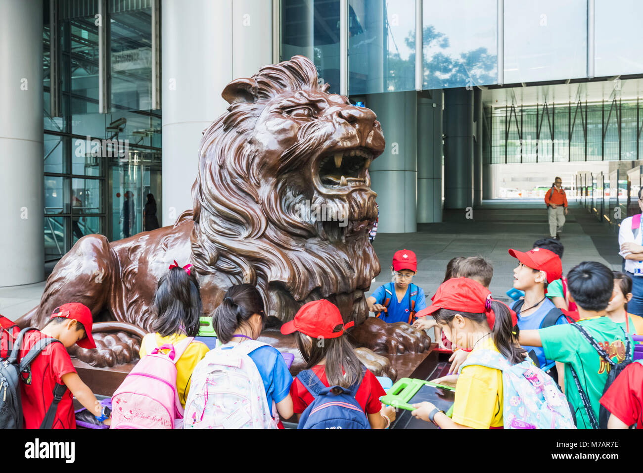 China, Hongkong, Central, Schulkinder und die HSBC Lion Statue Stockfoto