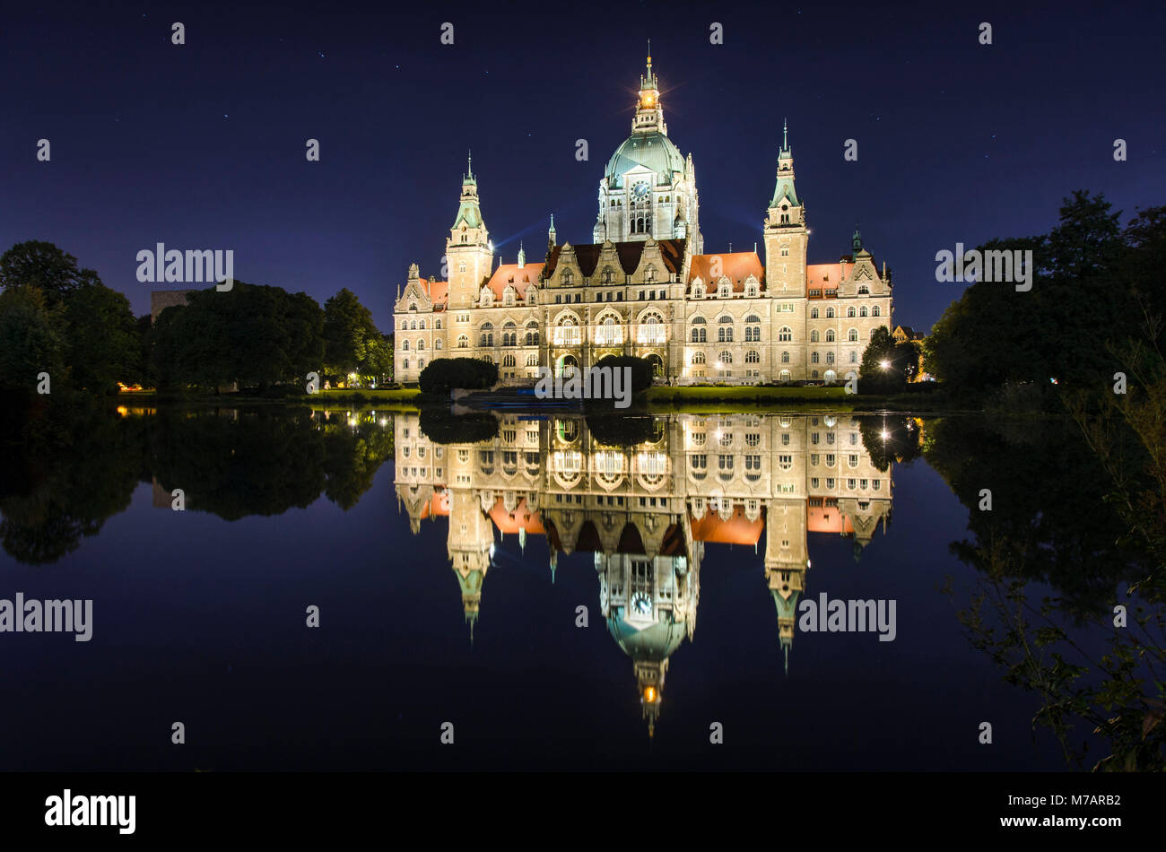 Rathaus der Stadt Hannover, Deutschland bei Nacht mit der Reflexion in einem See Stockfoto