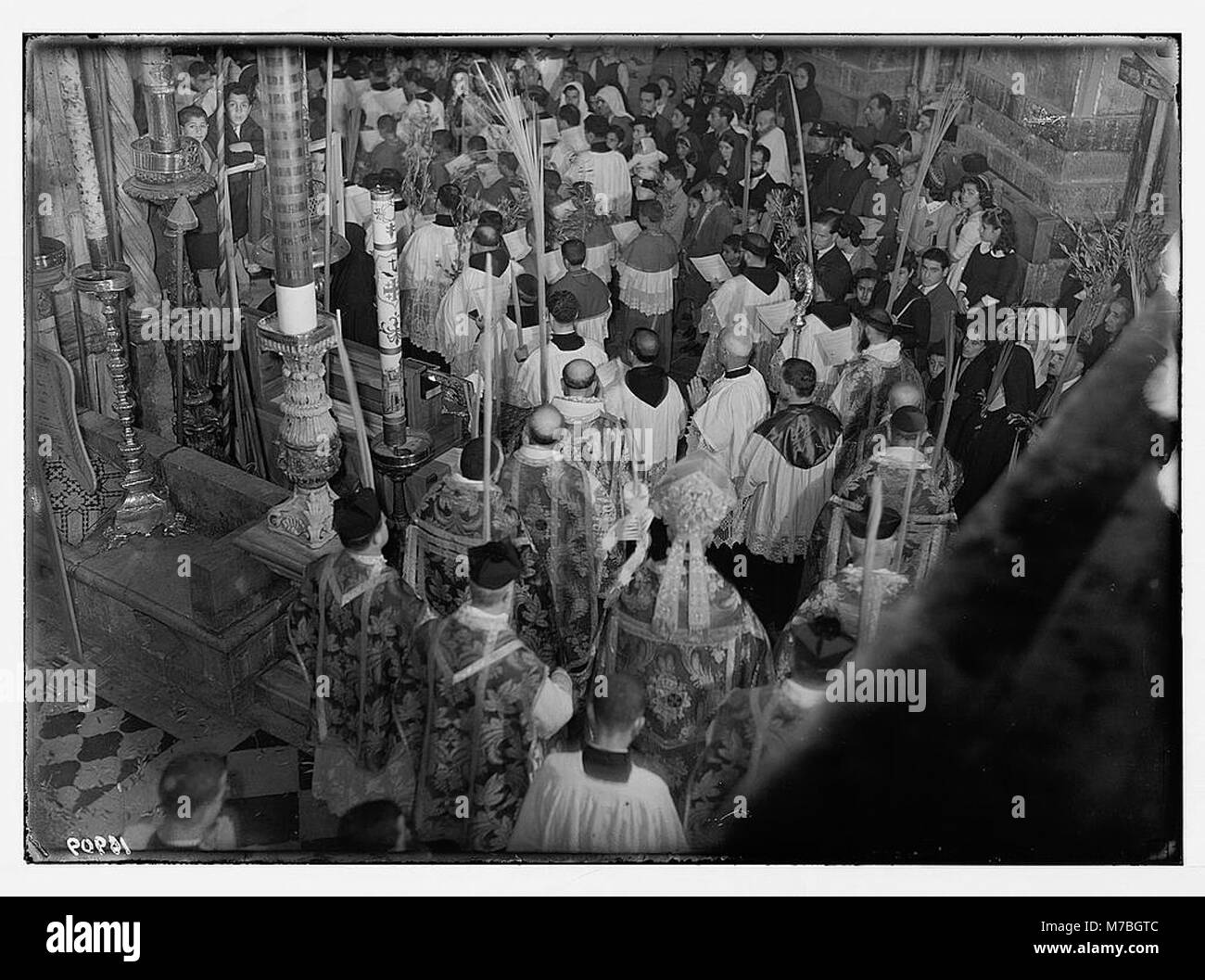Ein Foto aus der Osterzeit von 1941 in Jerusalem, das eine Palmensonntagsprozession zeigt, die das Heilige Grab verlässt und sich um die Rotunde bewegt. Die Veranstaltung beleuchtet die religiöse Einhaltung der christlichen Gemeinschaft. Stockfoto