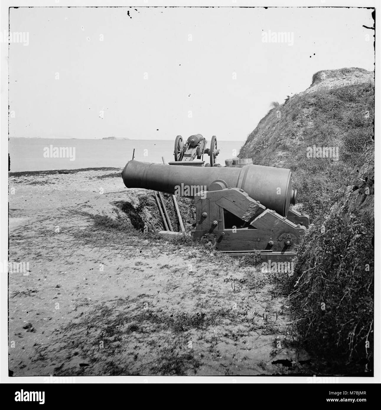 Ein Foto aus der Zeit des Bürgerkriegs von Fort Johnsons Waffen mit Fort Sumter in der Ferne, das Charlestons Militärgeschichte unterstreicht. Stockfoto