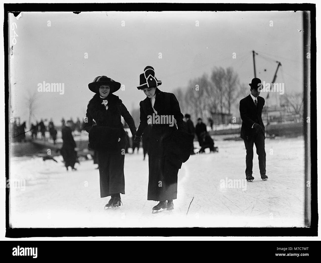 Ein Foto von einer Schlittschuhparty, auf der Leute gezeigt werden, die Schlittschuhlaufen. Das Bild zeigt die sozialen und Freizeitaktivitäten des Schlittschuhfahrens während der Wintermonate. Stockfoto