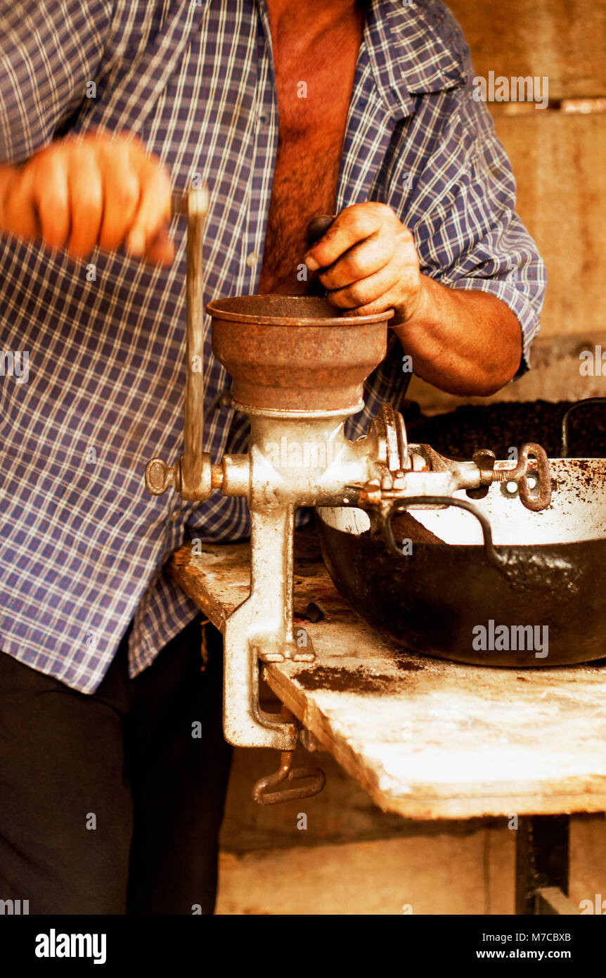 Man Schleifen gerösteten kolumbianischen Kaffee Bohnen, Kolumbien Stockfoto