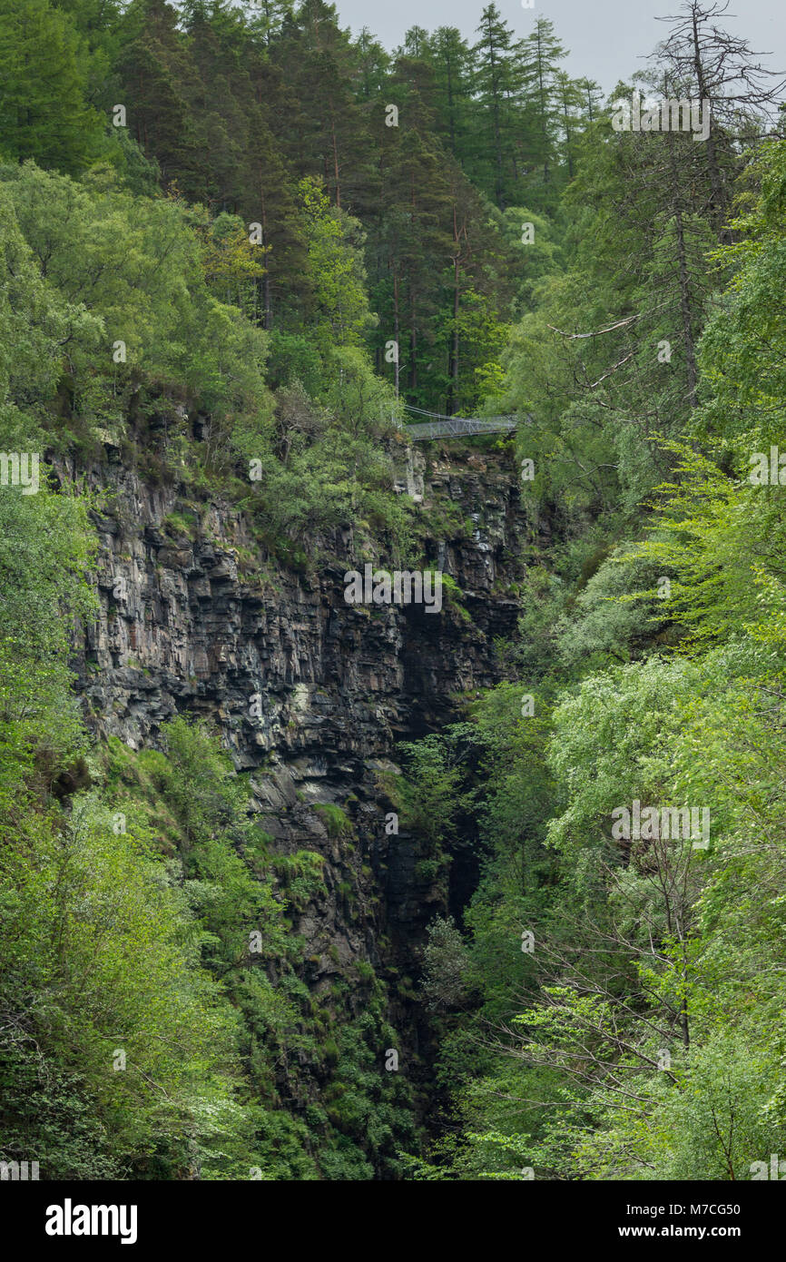 Nach Braemore, Schottland - Juni 8, 2012: corrieshalloch Gorge, einem tiefen Einschnitt in der Landschaft mit bewaldeten vertikale Pisten. Aufhängung Brücke über den Abgrund. Fokus auf Stockfoto