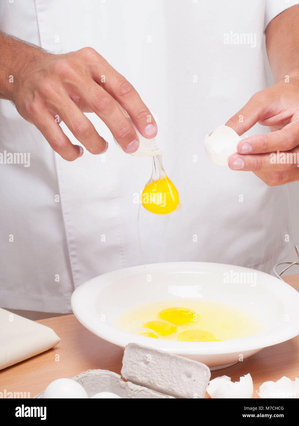 Mann bricht Eiern in eine Schüssel geben Stockfoto