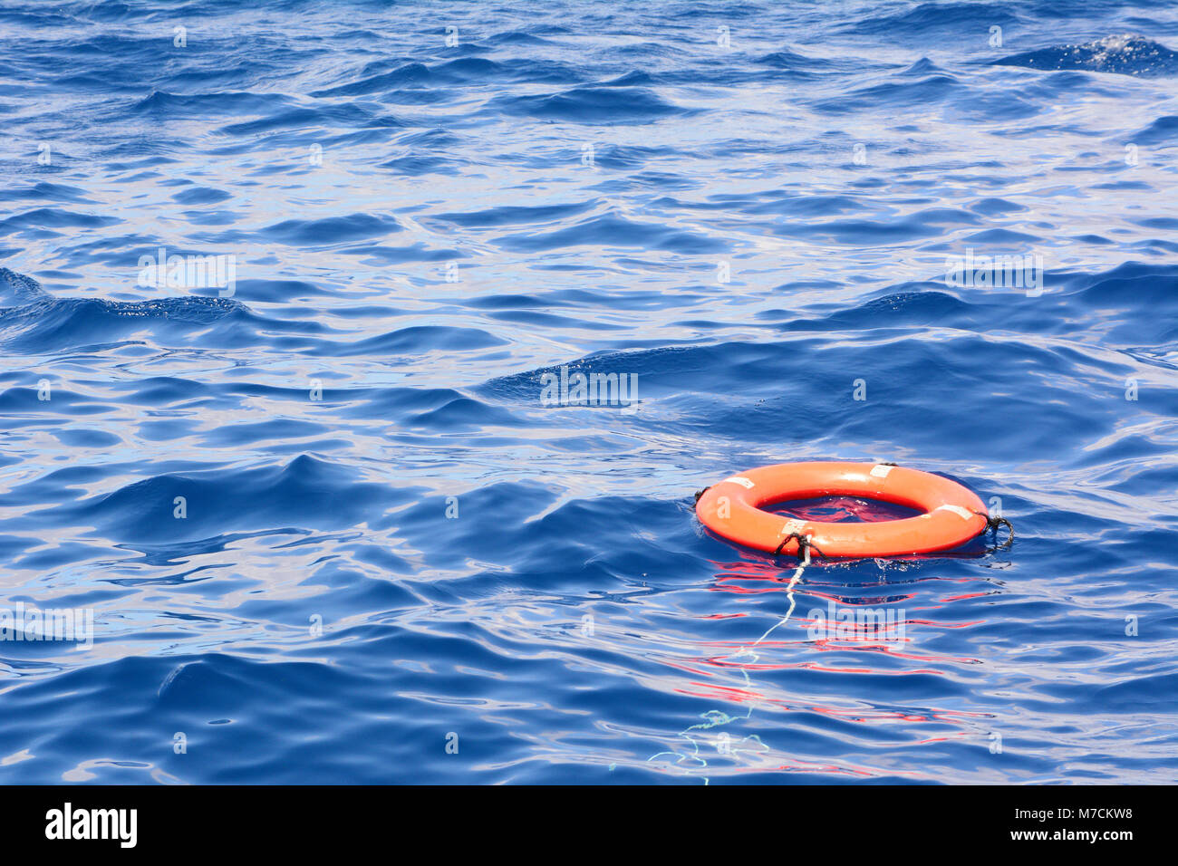 Tiefblaue Meer Wasser mit einem orangefarbenen Rettungsring im Wasser. Auf der Insel auf Grand Turk. Stockfoto