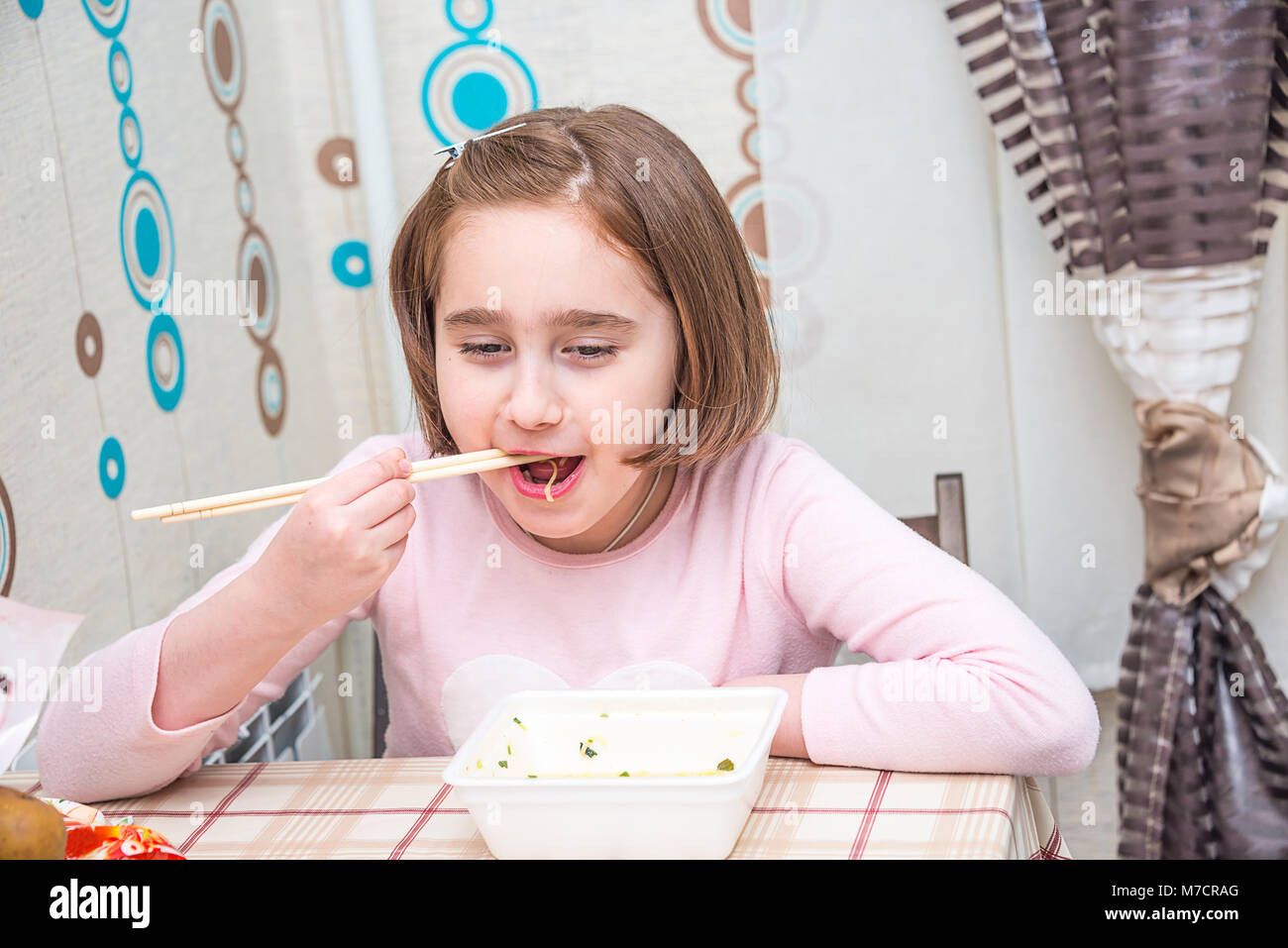 Kind ißt, chinesische Nudeln für die Tabelle, Einweggeschirr, Essstäbchen, Stockfoto