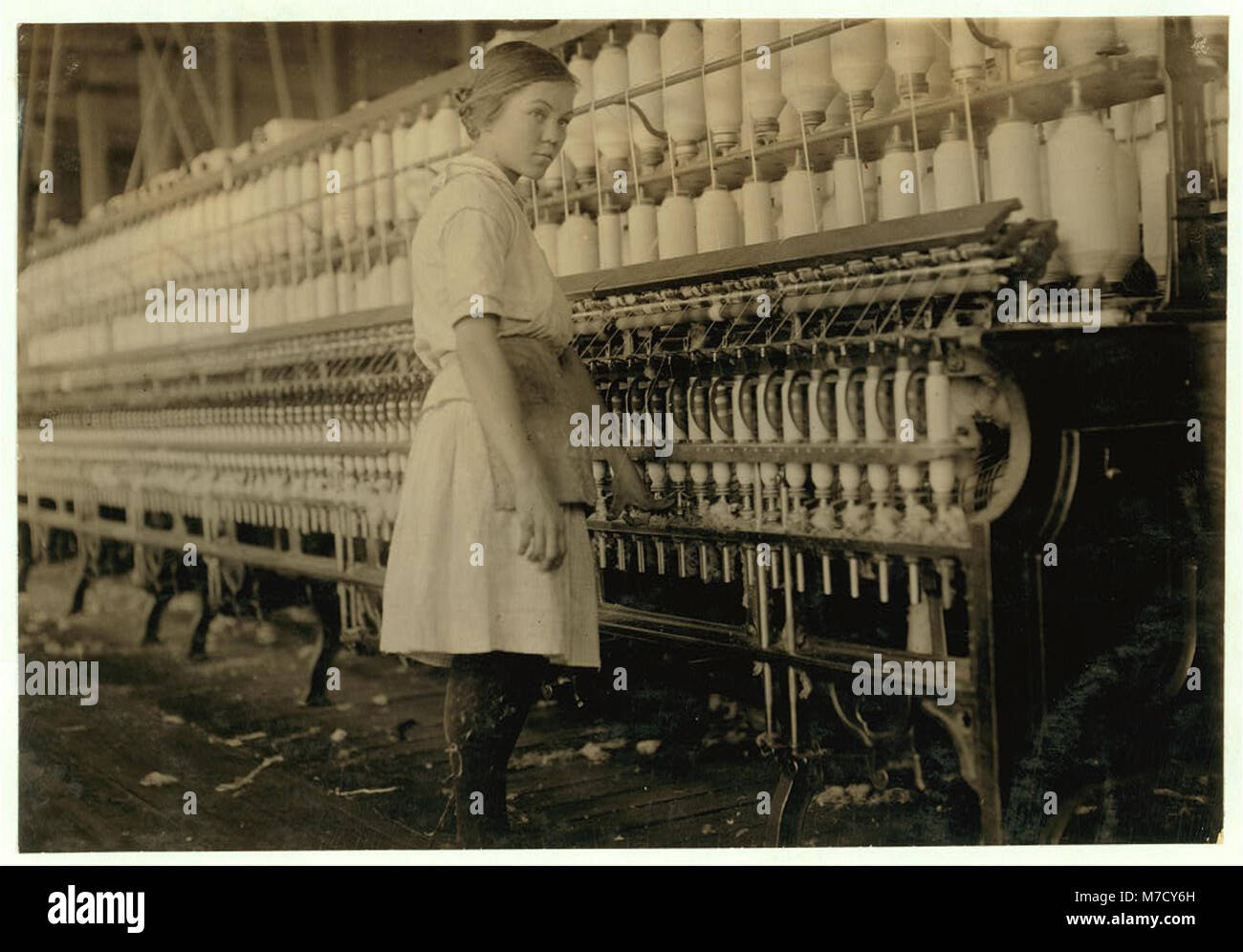 Dieses Bild zeigt ein vierzehnjähriges Kind, das als Spinner in einer Baumwollfabrik im Brazos Valley, Texas, arbeitet und dabei gegen die Arbeitsgesetze verstößt. Stockfoto