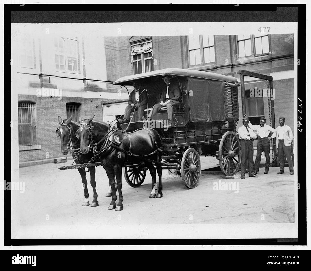 Ein historisches Foto, das einen Pferdewagen zeigt, der vor dem Büro für Gravur und Druckerei geparkt ist und das amerikanische Transportmittel aus dem frühen 20. Jahrhundert erfasst. Stockfoto