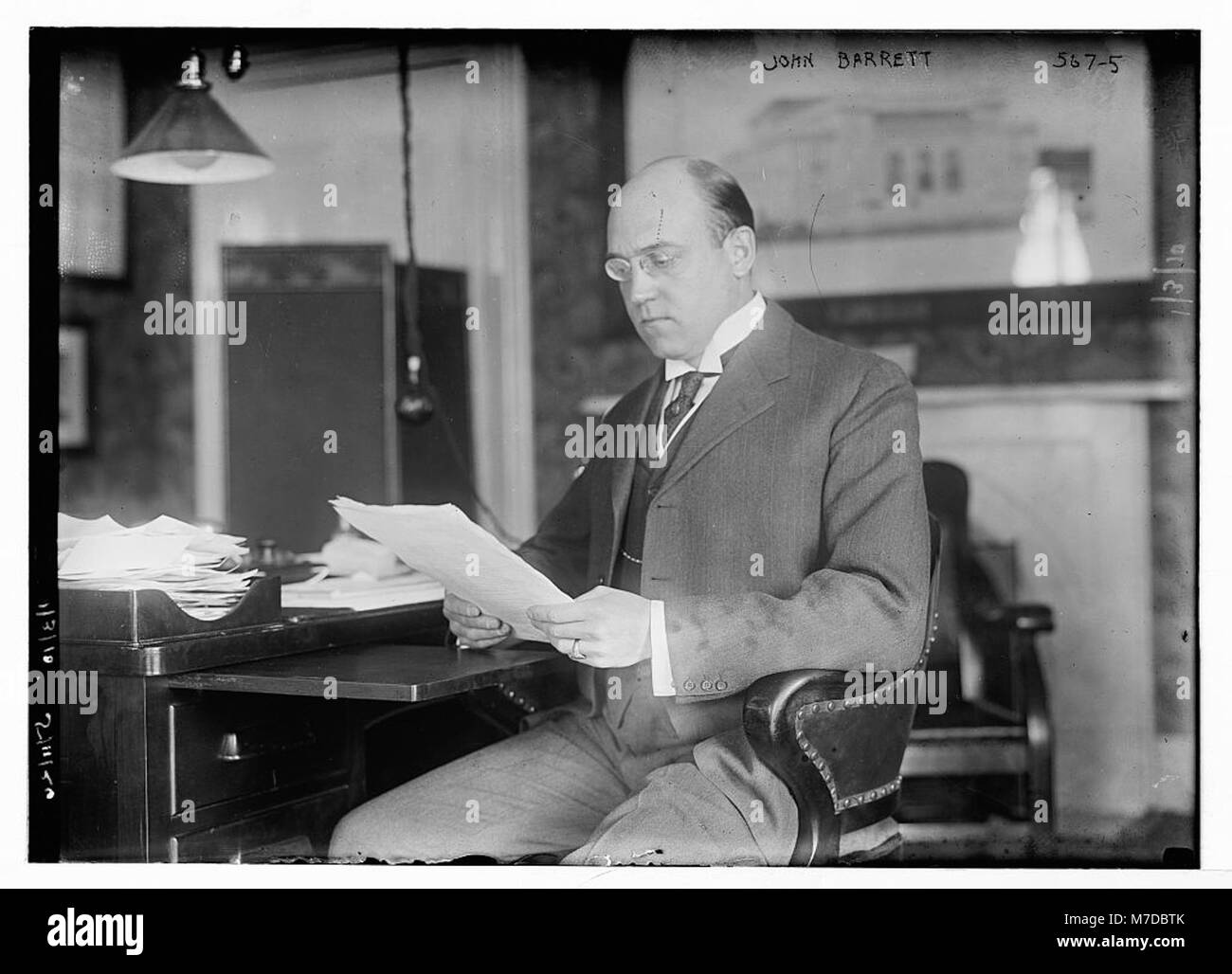 John Barrett, ein prominenter amerikanischer Diplomat und Geschäftsmann, wird auf diesem historischen Foto an einem Schreibtisch dargestellt. Barrett war in seiner Zeit maßgeblich an den internationalen Beziehungen beteiligt. Stockfoto