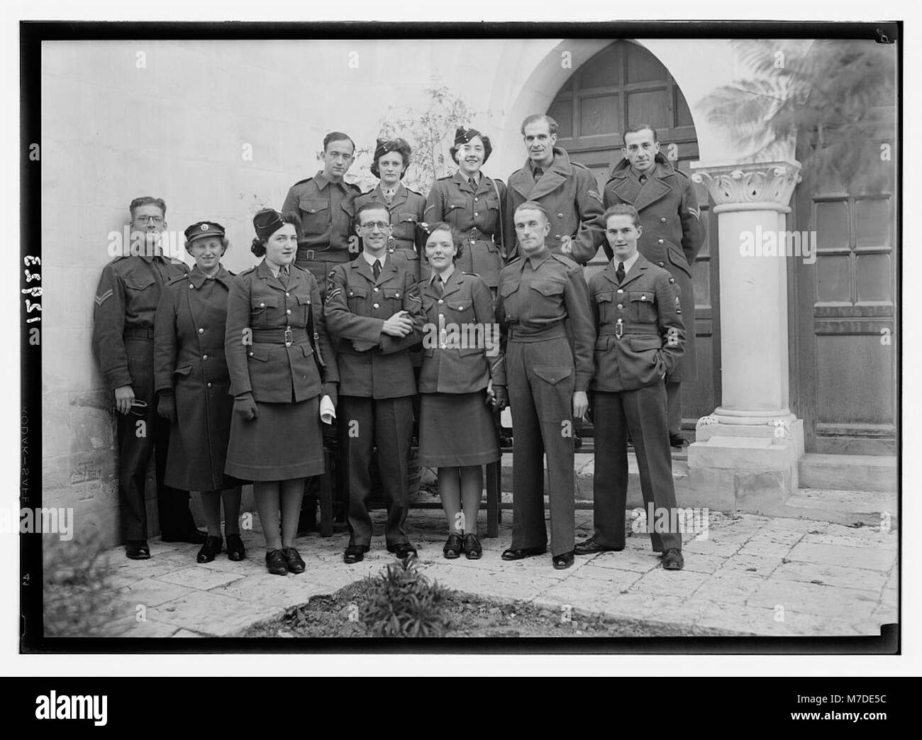 Ein Hochzeitsfoto, das eine große Gruppe aus Braut, Bräutigam und ihren Freunden zeigt und einen Moment der Feier festhält. Dieses Bild spiegelt die sozialen Bräuche und Kleidung wider, die für Hochzeitszeremonien der damaligen Zeit typisch sind. Stockfoto