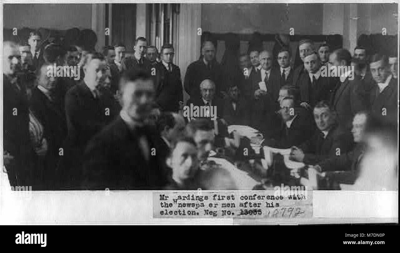 Dieses Bild zeigt die erste Pressekonferenz von Präsident Warren G. Harding mit Zeitungsleuten nach seiner Wahl. Sie spiegelt die politische Atmosphäre der frühen 1920er Jahre und Hardings Medieninteresse wider. Stockfoto