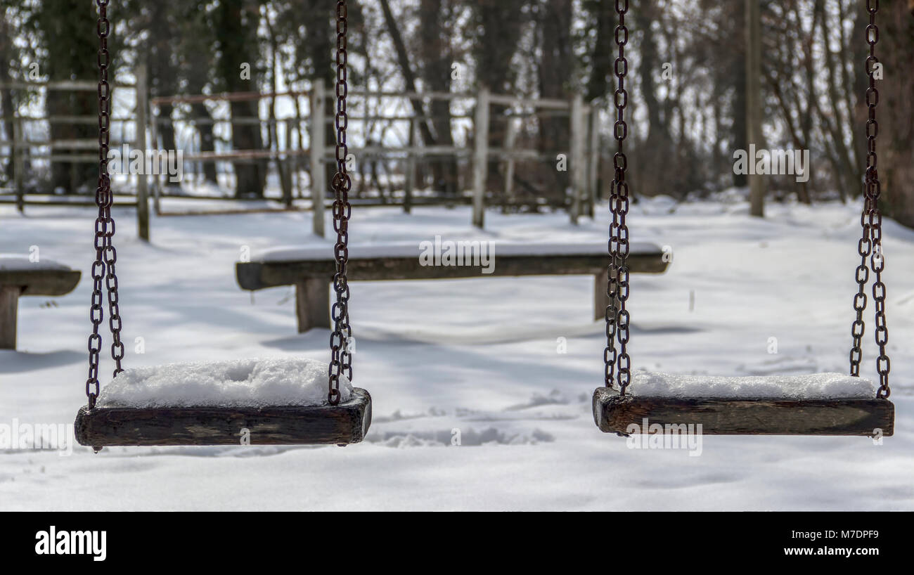 Bojcin Park Wald, Serbien - Schnee bedeckten schwingen in einem Kinderspielplatz im Park Stockfoto