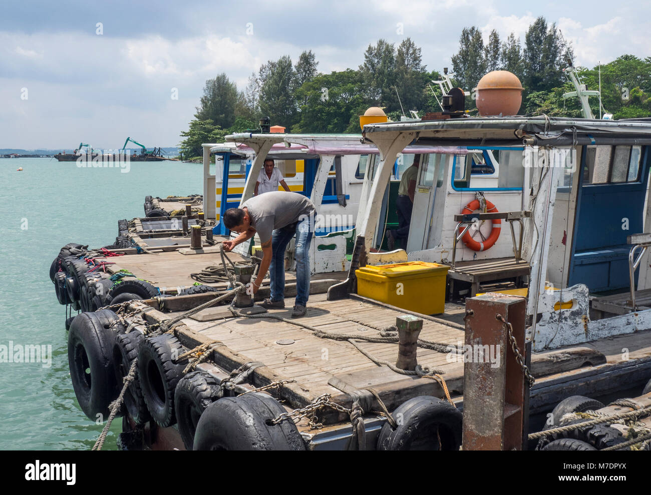 Besatzungsmitglieder auf der Rückseite des bumboats am Fährhafen der Insel Pulau Ubin, Singapur. Stockfoto