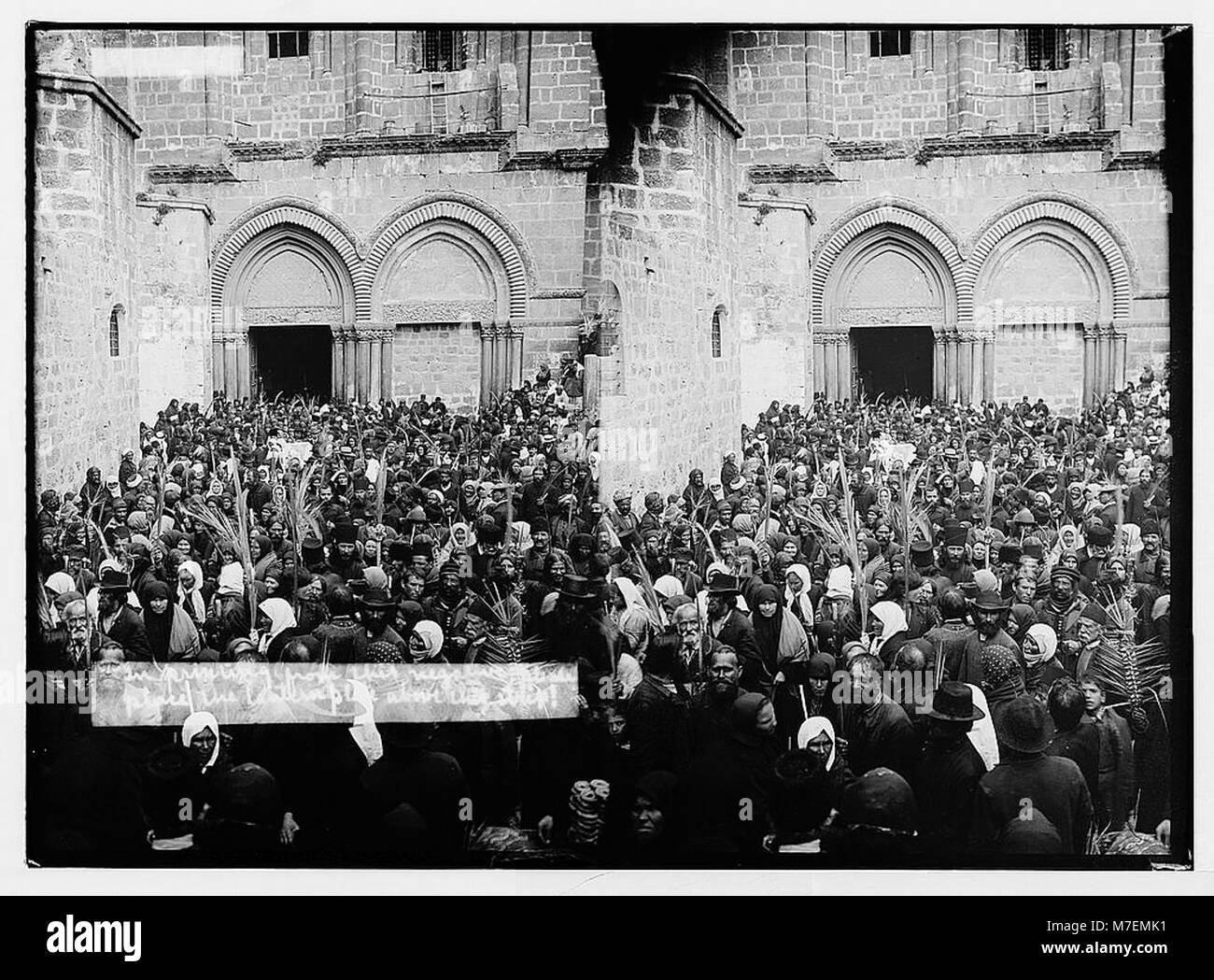 Dieses Foto zeigt die Grabeskirche in Jerusalem während der Palmsonntagsprozession. Es fängt das religiöse Ereignis mit Teilnehmern in traditioneller Kleidung ein und erinnert an ein bedeutendes christliches Ritual an einer historischen Stätte. Stockfoto
