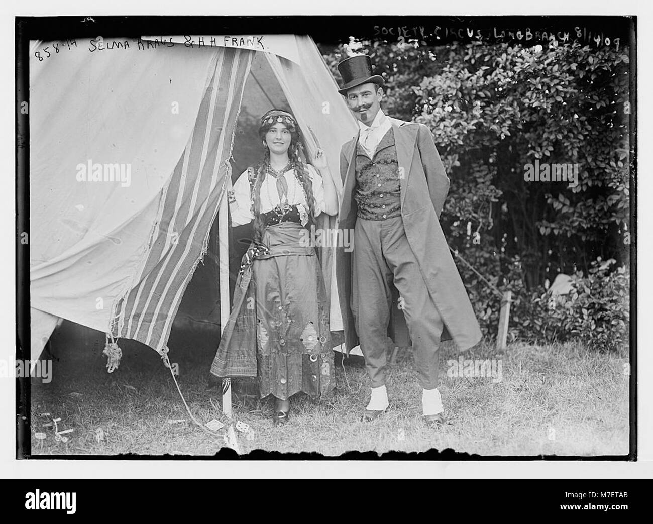 Dieses Foto zeigt Selma Kraus und H.H. Frank in Kostümen bei einer Society Circus Veranstaltung vor dem Zelt in Long Branch, die einen Moment der sozialen Unterhaltung im Amerika des frühen 20. Jahrhunderts festhalten. Stockfoto