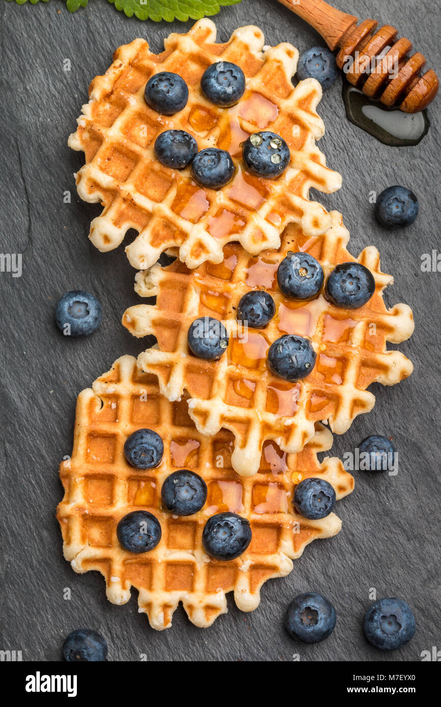 Wiener Waffeln mit Honig und frischen Beeren Heidelbeeren und Minze auf ...