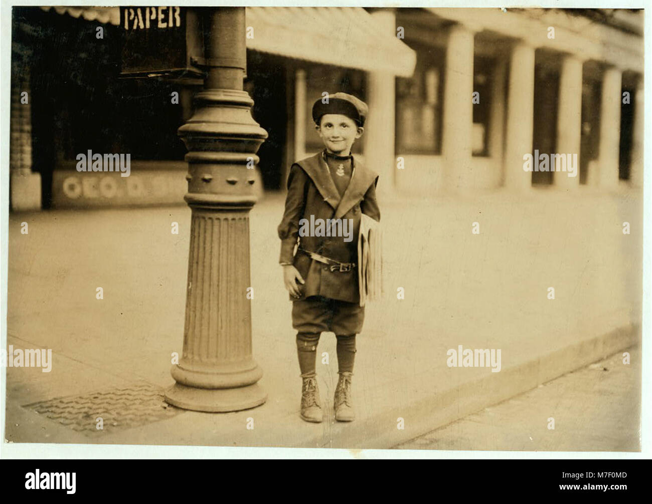 Ein 7-jähriger Zeitungsjunge, der nicht mit einem Abzeichen gekennzeichnet ist, wird in einem Moment dargestellt, in dem er verdächtigt wurde, einen Kunden beim Verkauf von Zeitungen zu kurzfristig zu wechseln. Das Foto zeigt eine Momentaufnahme der Jugend im urbanen Leben während dieser Zeit. Stockfoto