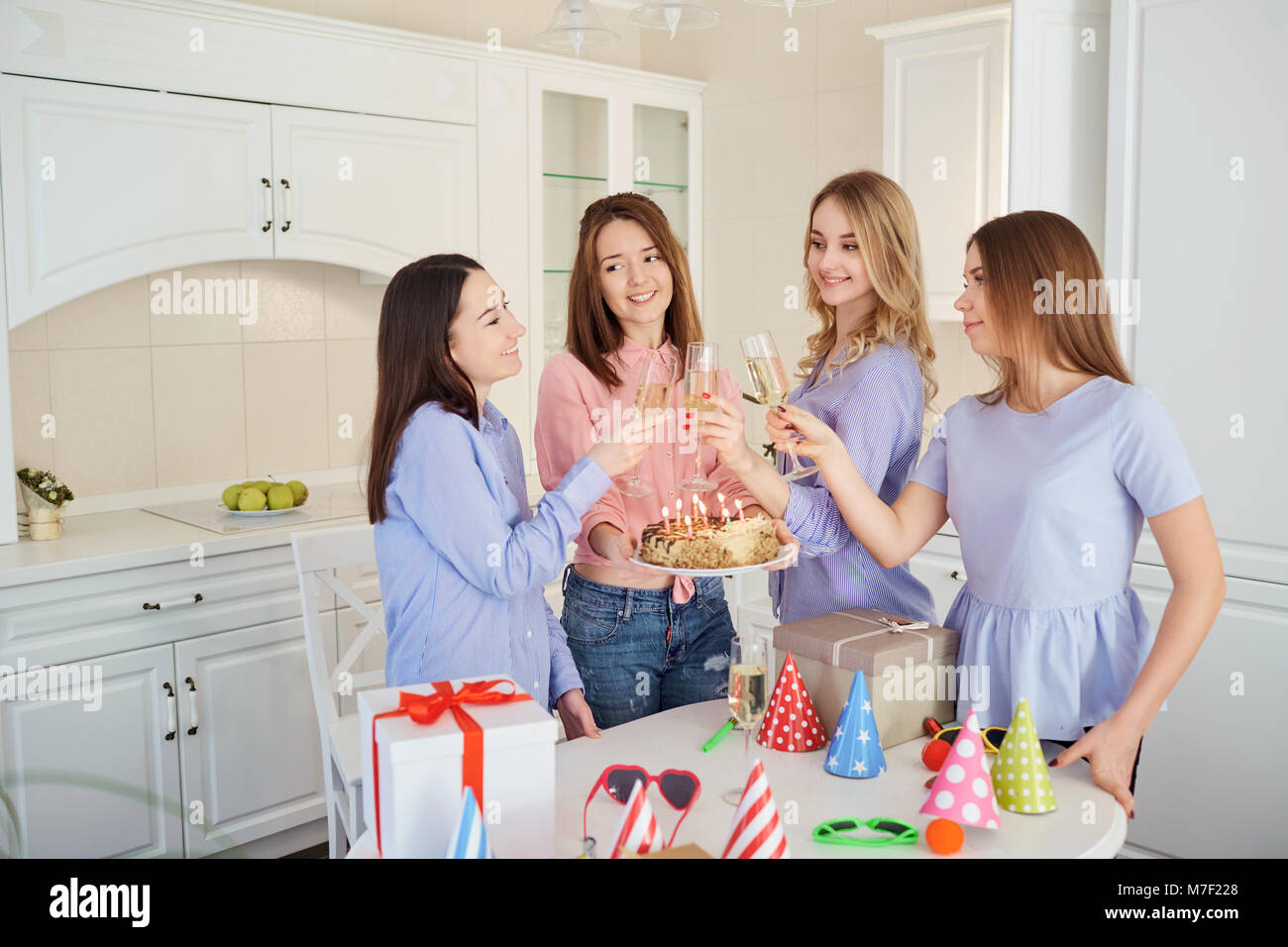 Eine Gruppe von Freundinnen mit einem Kuchen mit Kerzen feiern eine birt Stockfoto