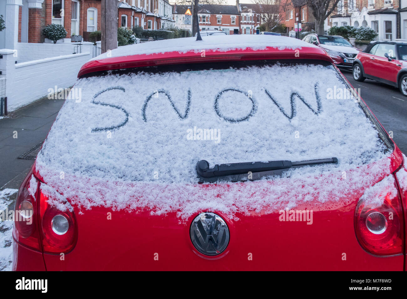 Das Wort Schnee auf der Heckscheibe eines schneebedeckten Auto geschrieben. Stockfoto