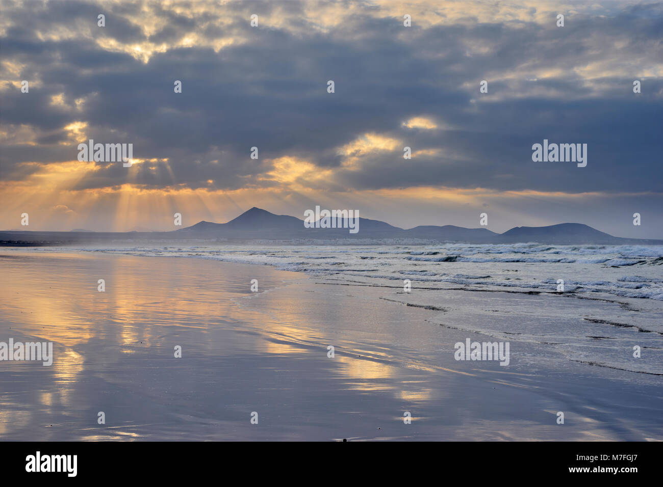 Playa de Famara, Lanzarote, Kanarische Inseln, Spanien. Blick auf soo bei Sonnenuntergang mit Sky am Strand nieder Stockfoto