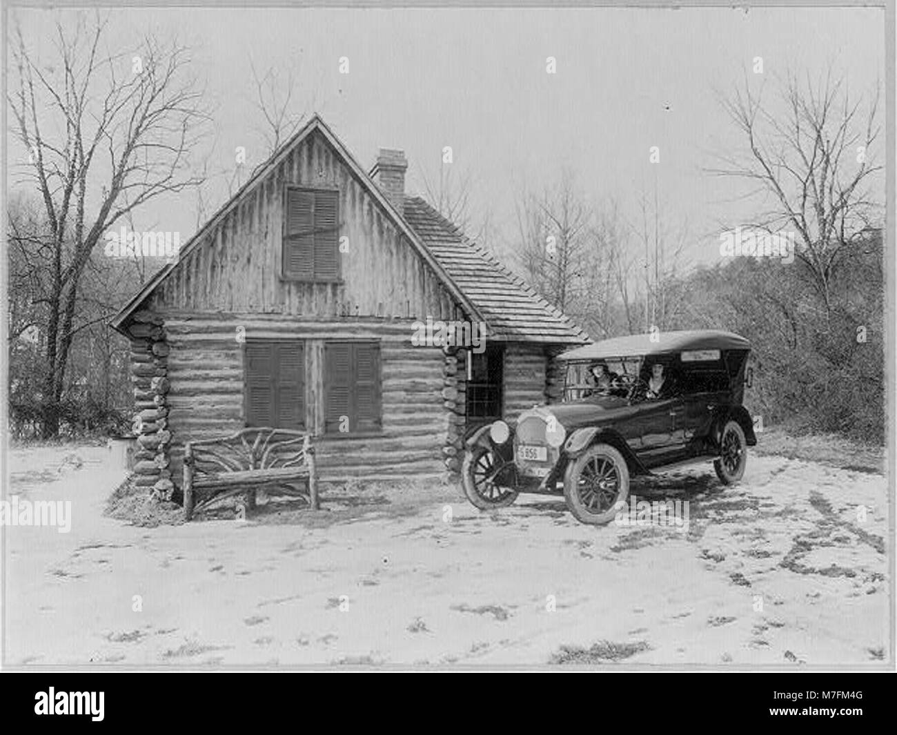 Foto mit zwei Frauen in einem neuen Oldsmobile Auto, das vor einer Blockhütte im Rock Creek Park, Washington, D.C. geparkt ist. Das Bild wurde für Werbezwecke von Oldsmobile Sales Co. Erstellt und zeigt das Design des Autos und die Umgebung des Parks. Stockfoto
