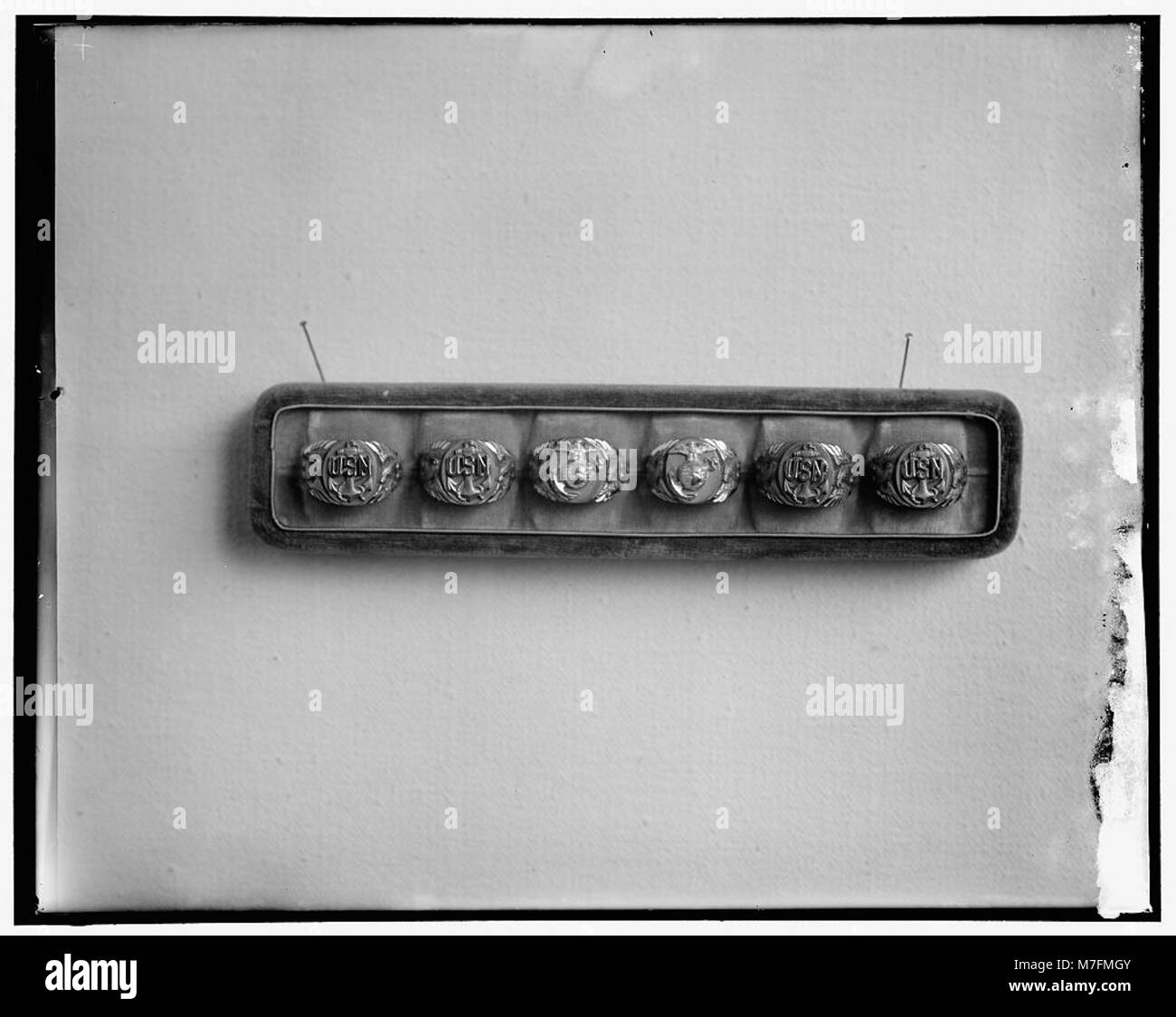 Eine Sammlung von Ringen, die die U.S. Navy und Marine Corps repräsentieren und die Insignien und Traditionen dieser militärischen Zweige zeigen. Stockfoto