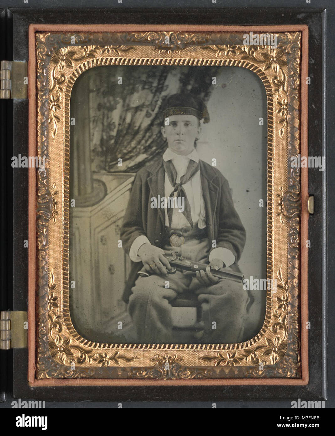 Ein Foto eines nicht identifizierten Soldaten, der eine Uniform der Konföderierten trägt und eine Schlagpistole hält, die eine bedeutende Periode der amerikanischen Bürgerkriegsgeschichte darstellt. Stockfoto