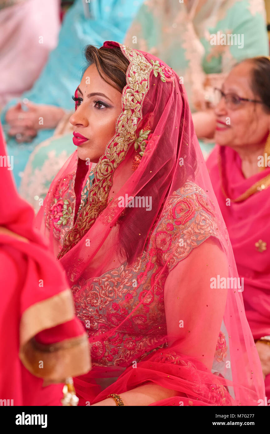 Die Frauen sitzen in Gurdwara in einem Indischen Sikh Hochzeit Stockfoto