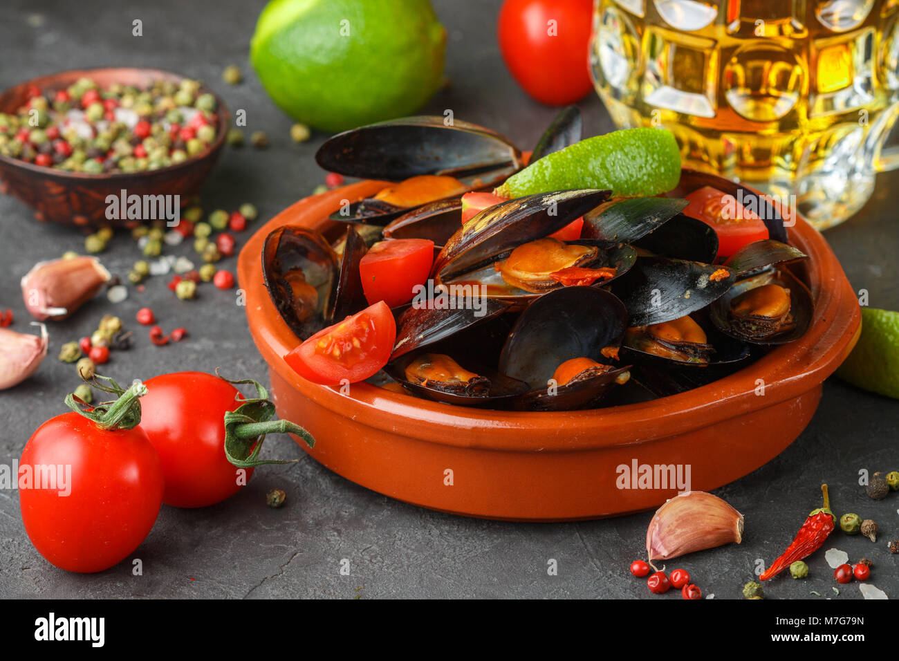 Muscheln in Tanks mit Tomaten und würziger Sauce aus Chili und Knoblauch. Leckeren Snack zum Bier. Mediterrane Gerichte. Selektiver Fokus Stockfoto