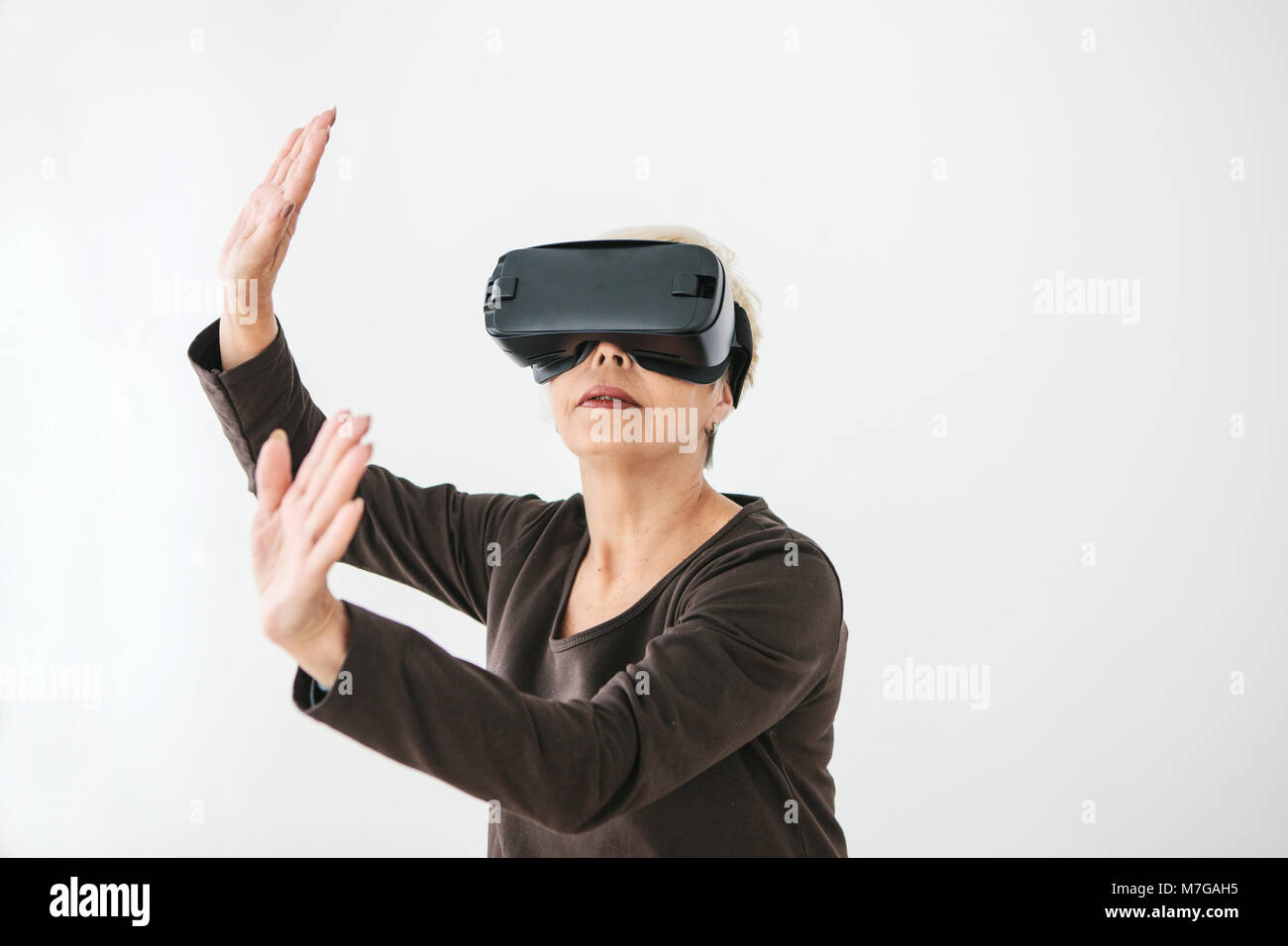 Eine ältere Frau in der virtuellen Realität Gläser. Eine ältere Person mit moderner Technologie. Stockfoto