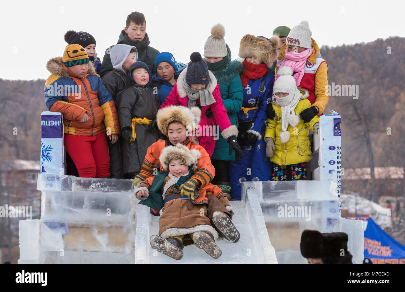 Hatgal, Mongolei, 4. März 2018: mongolische Kinder in traditioneller Kleidung auf einem zugefrorenen See Khuvsgul, unten kommen, eine Folie madeout von Eis Stockfoto