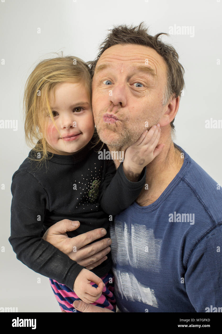 Vater und Tochter machen lustige Gesichter im Studio Stockfoto
