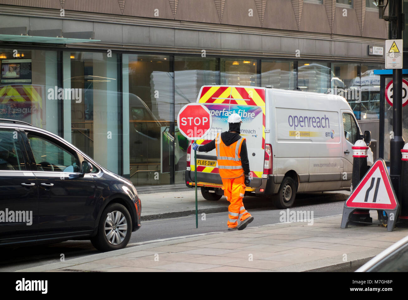 Arbeiter in der High vis halten Sie Stop-Zeichen vor der BT Openreach superfast Fibre van Stockfoto